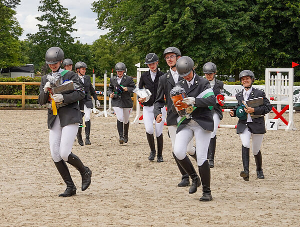 Viele Menschen in Reitsachsen rennen über einen Reitplatz