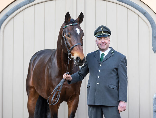 Ein Mann in Uniform mit einem braunen Pferd